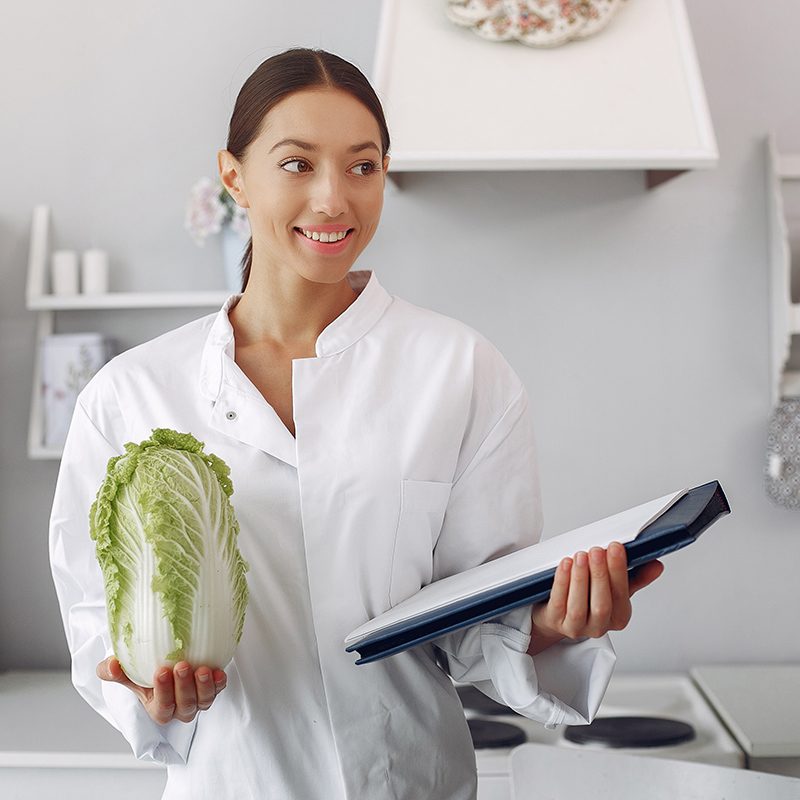 Healthy eating. Dieting and people concept. Brunette with a vegetable. Doctor with a notebook